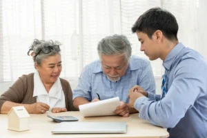 Elderly couple signing paper work with a lawyer.