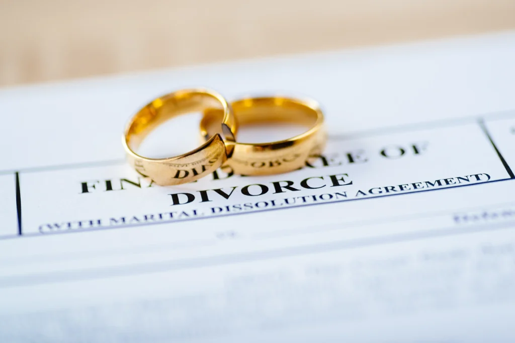 Paperwork that says divorce with two golden rings.