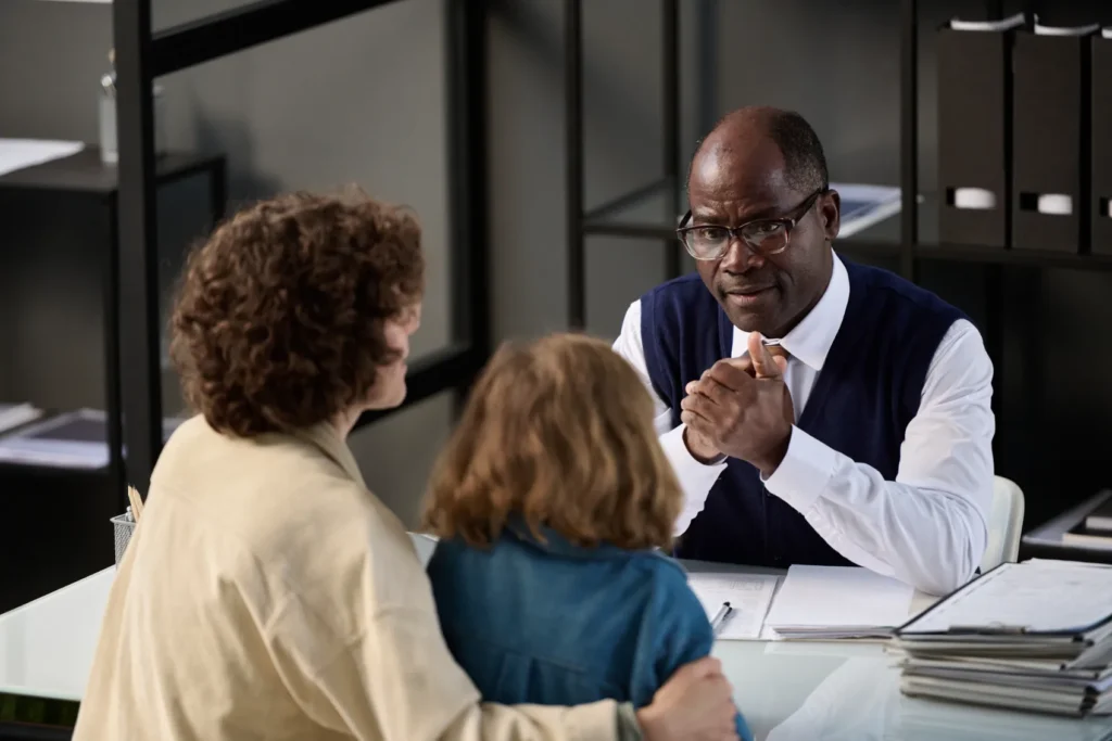 A mom meeting with a lawyer, with a young child sitting next to her.