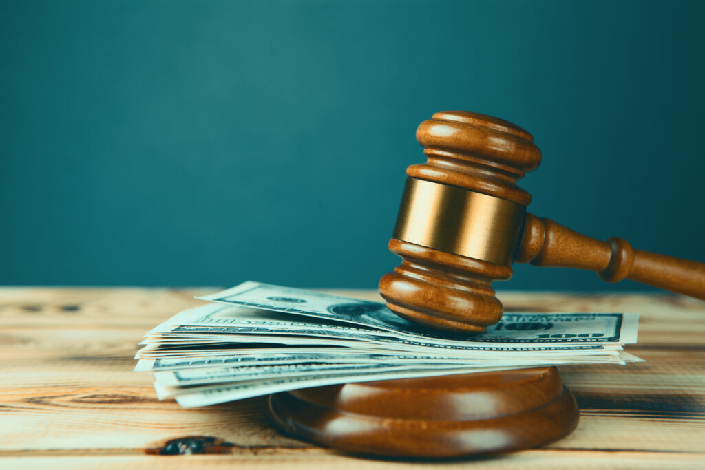 A gavel with a stack of dollar bills.